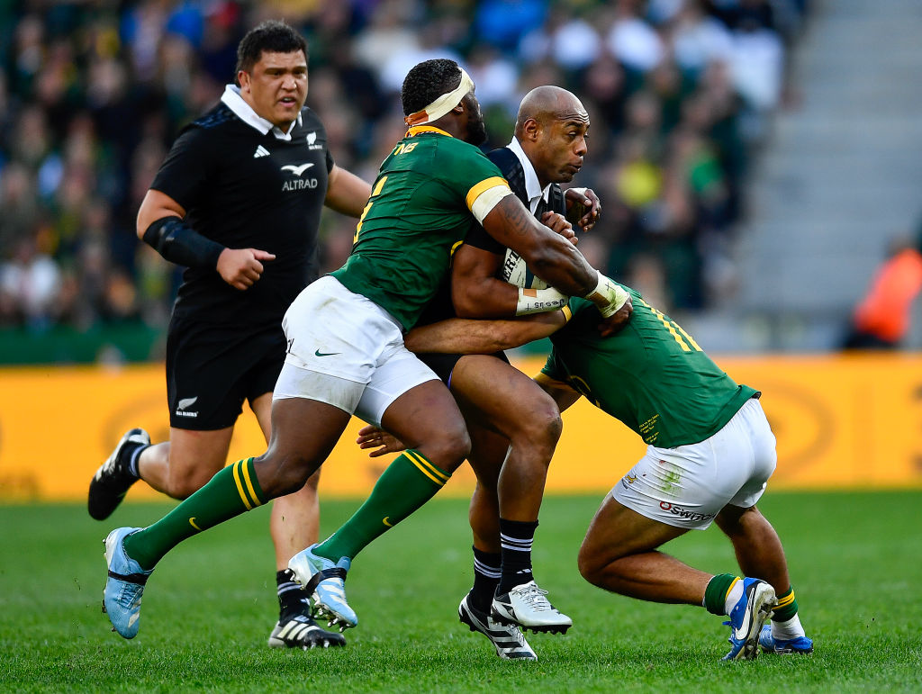 Mark Tele'a of the All Blacks tackled by Damian de Allende and Siya Kolisi (captain) of the Springboks during the Castle Lager Rugby Championship match between South Africa and New Zealand at DHL Stadium on September 07, 2024 in Cape Town, South Africa. (Photo by Ashley Vlotman/Gallo Images/Getty Images)